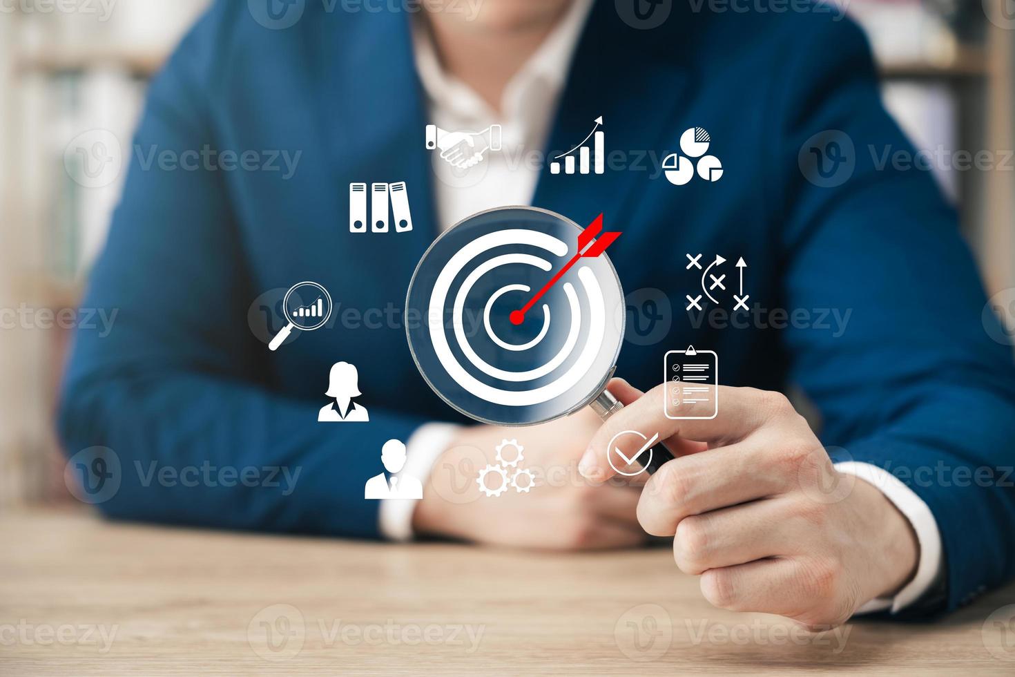 Businessman showing magnifying glass focusing on goal icon, corporate development and global business leadership, success, strategy, prospects, sustainable goals. photo