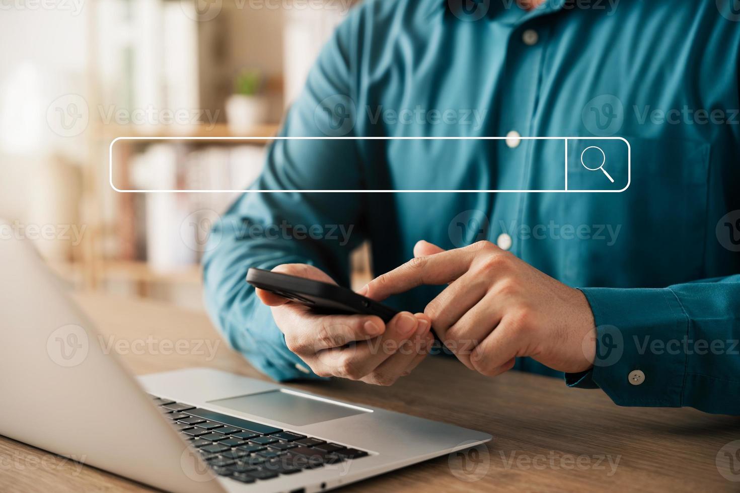 búsqueda de información de datos de Internet con barra de búsqueda en blanco. hombre de negocios que trabaja con un teléfono inteligente, una tableta y una computadora portátil en el escritorio de la oficina. concepto de red. foto