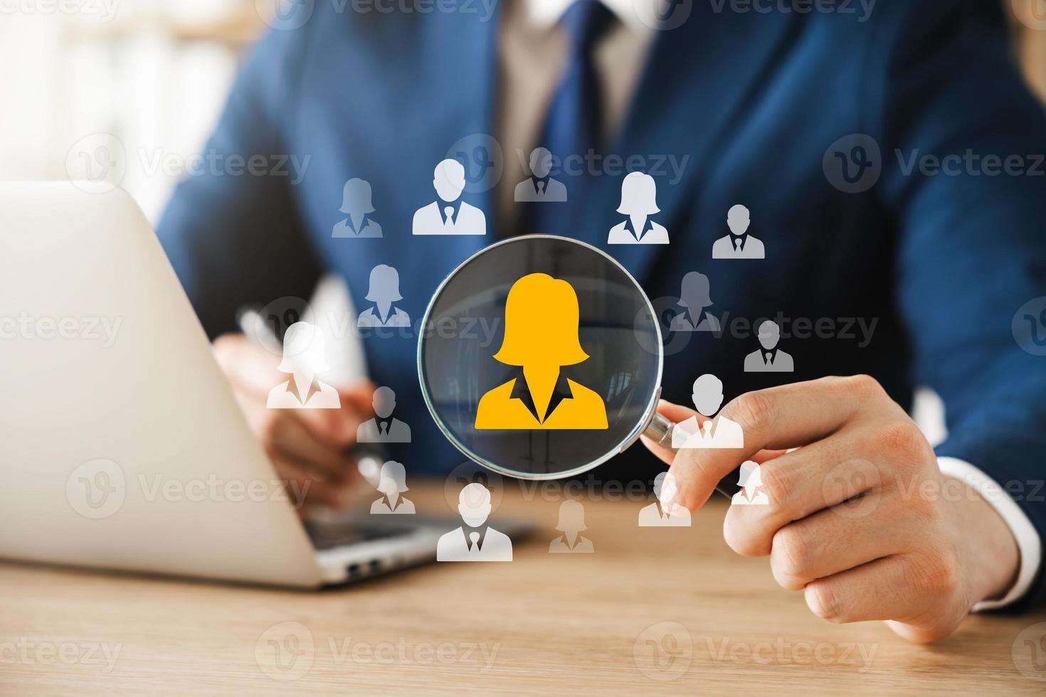 HRM human resource management concept, executive holding a magnifying glass to search for effective personnel, human resource management in the organization, human development and recruitment. photo