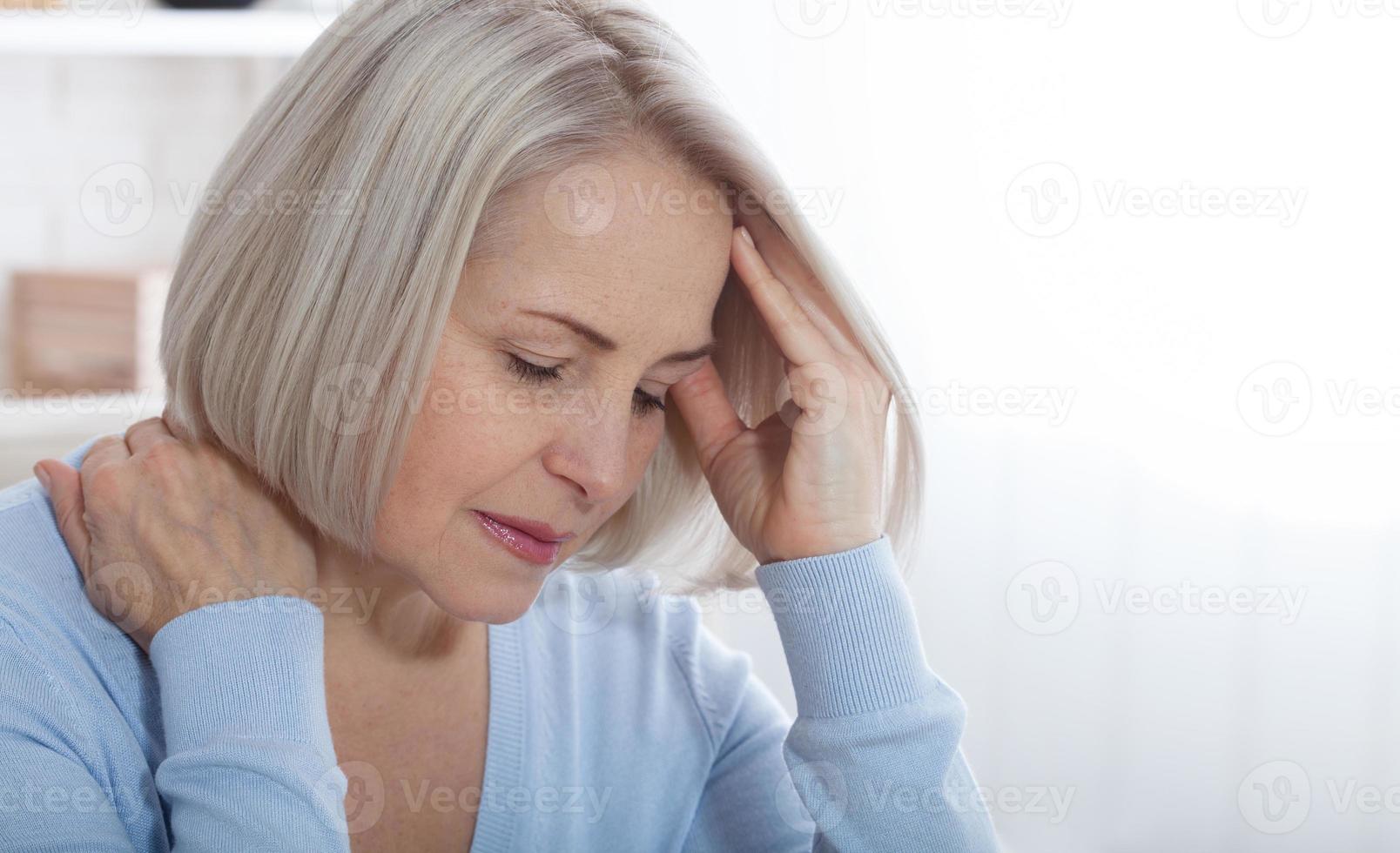 Concept coronavirus, covid-19 respiratory virus with indicating location of the pain.Woman suffering from stress or a headache grimacing in pain as she holds the back of her neck photo