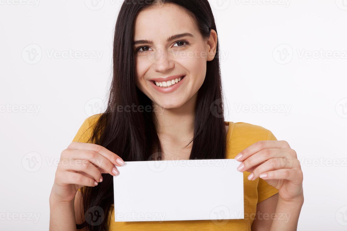 Your text here. Pretty young woman holding empty blank board. Studio portrait on white background. Mock up for design photo