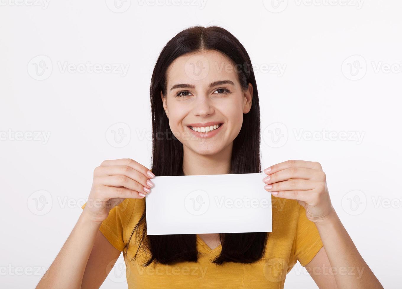 Your text here. Pretty young woman holding empty blank board. Studio portrait on white background. Mock up for design photo