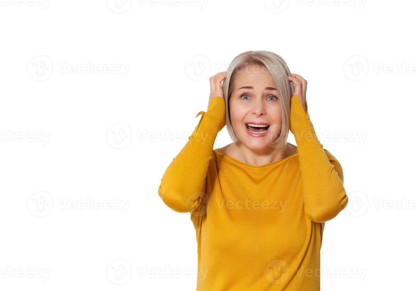 Attractive Middle Aged Woman expresses fear and horror, panic and cry, hysterics and problem, surprise and fright. Woman in bright clothes posing in studio on white background photo