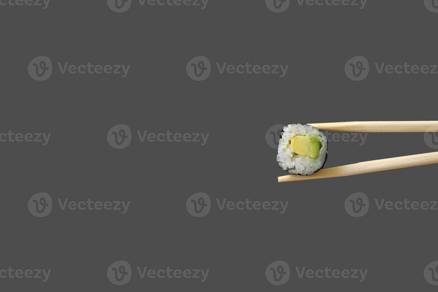 fresh vegetarian maki sushi roll with wooden chopsticks isolated on grey background. copy space photo