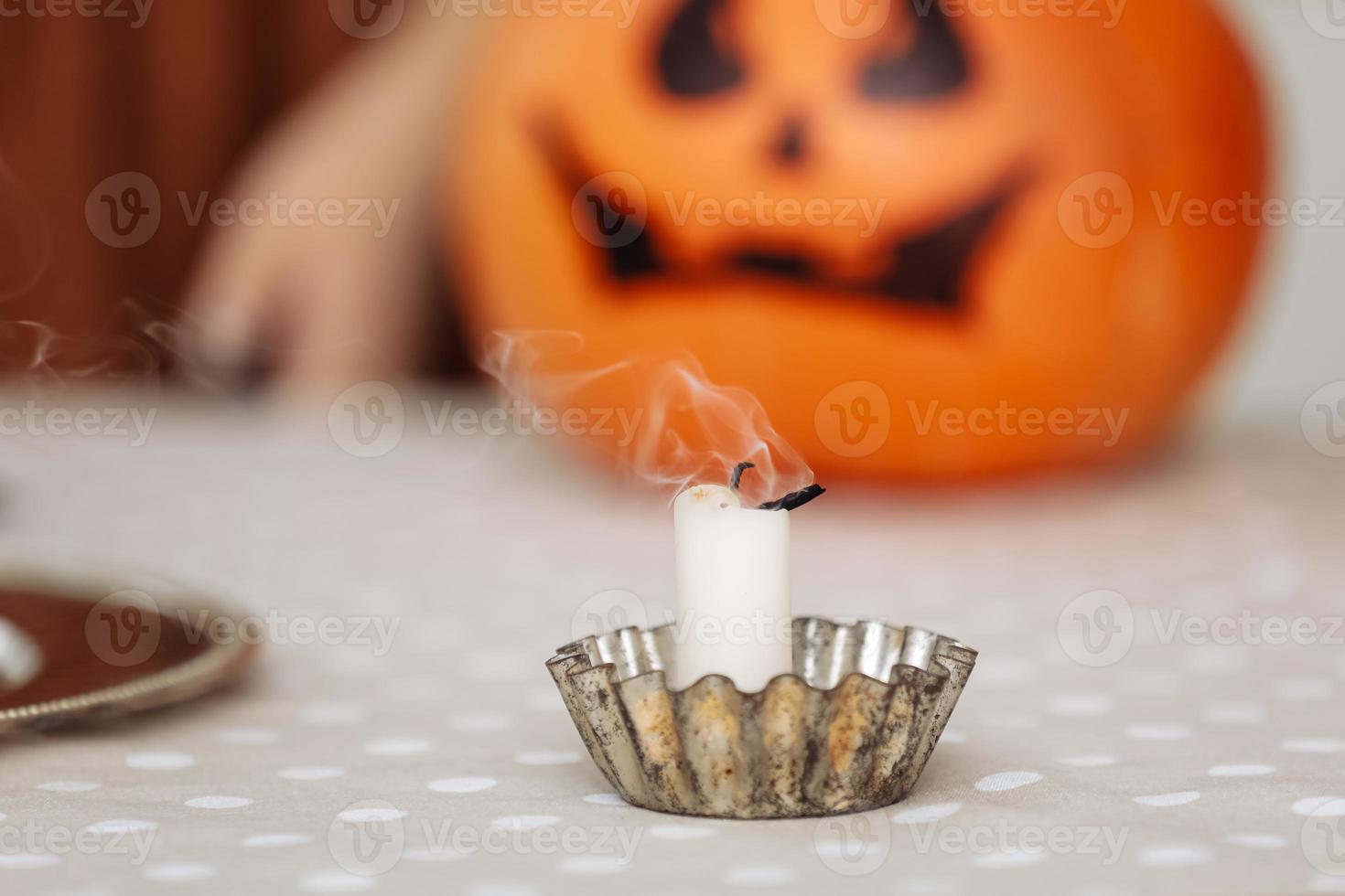 burning candles close up on a background of pumpkins. Halloween pumpkin head jack lantern with burning candles. illuminated halloween pumpkins with candles in the kitchen. photo