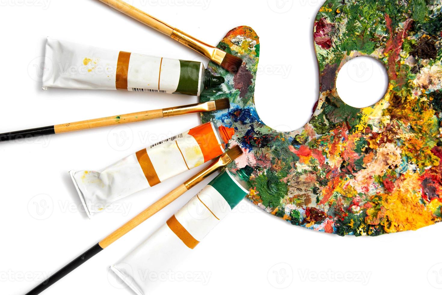 Palette with colorful paints. Colorful oil painting palette with a brush reaching in. Paint brushes and paints for drawing. tulip on a white background photo