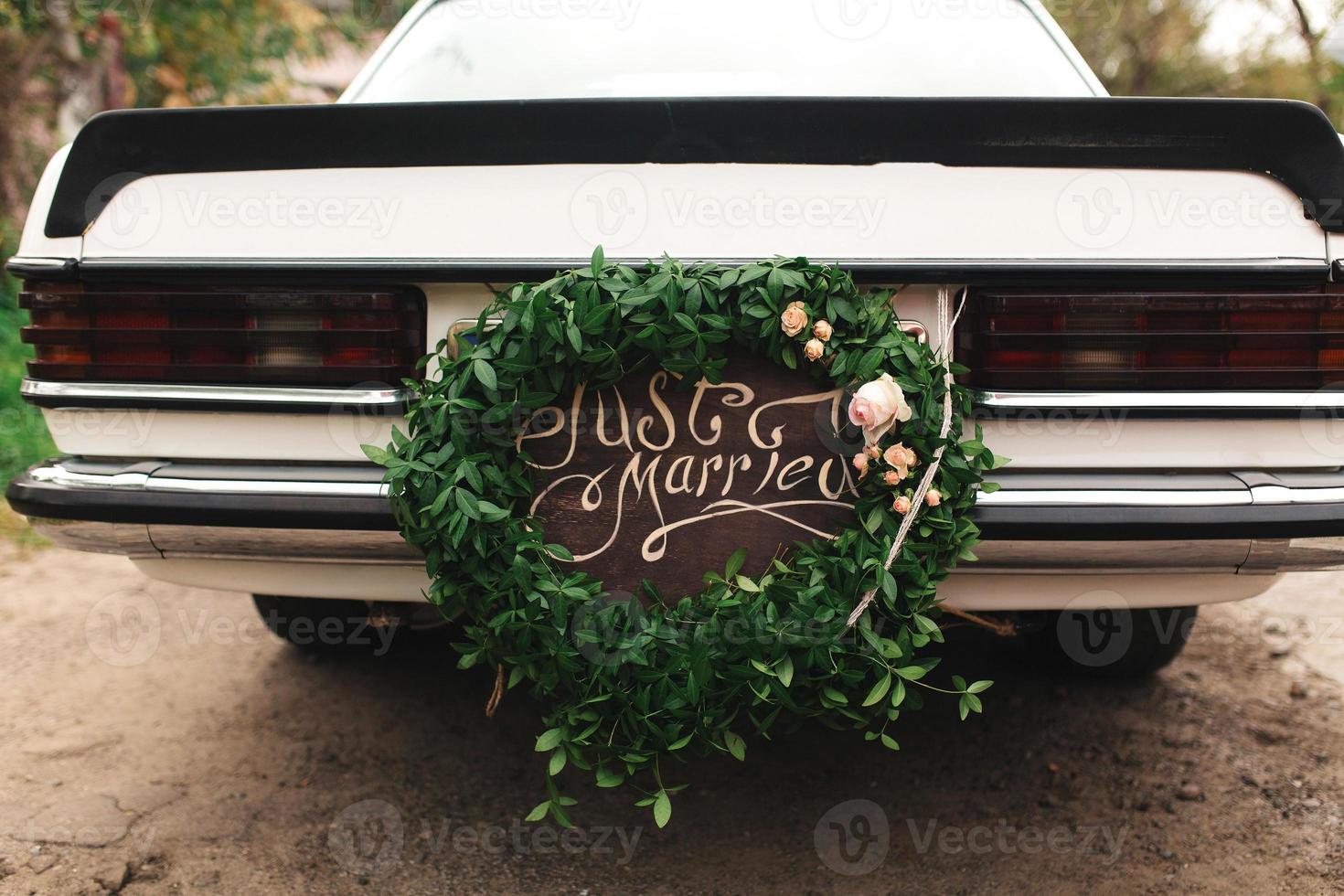 auto recién casado. hermoso coche de bodas con placa recién casados foto