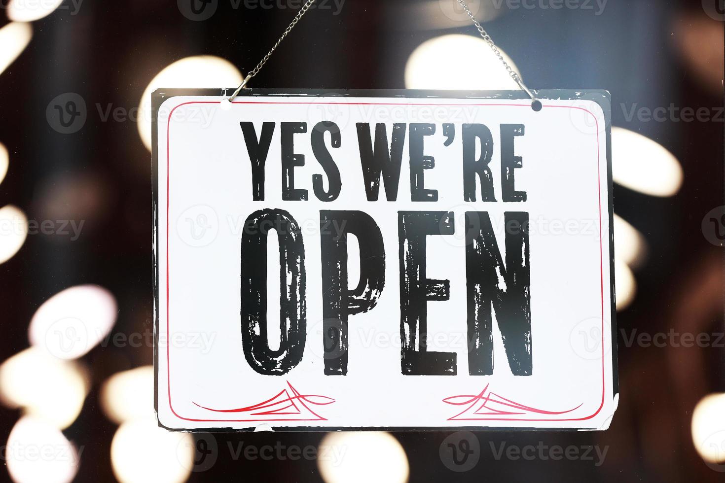 Inscription Yes we're open metal plate with black and white sign on glass door store, cafe, beautystore, barbershop after coronavirus lockdown quarantine. business reopen again photo