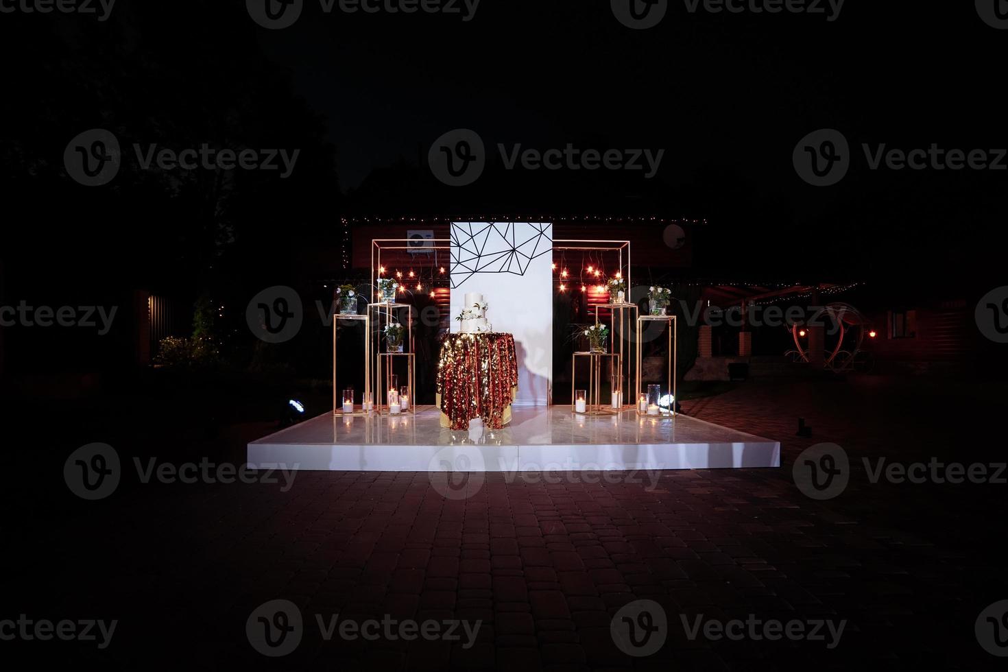 Table with a wedding cake, candles, light and flowers. wedding decoration photo