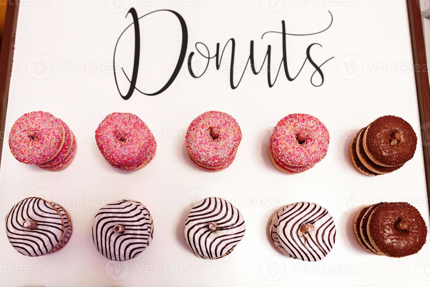 wedding chocolate donuts for guests. festive concept. sweets on a wedding day. wedding donuts. A yummy donut wall. photo