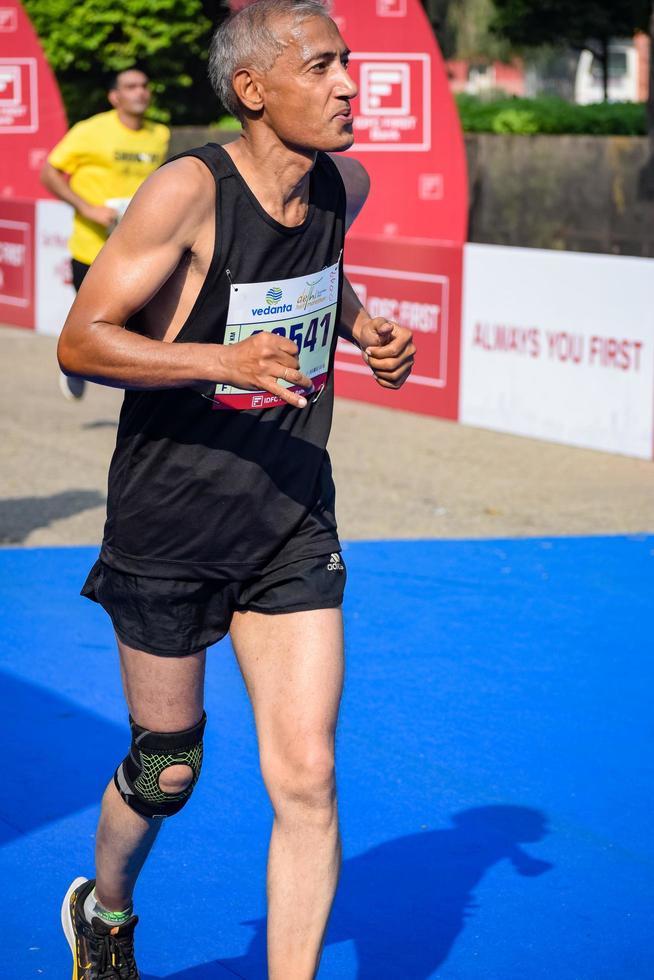 New Delhi, India - October 16 2022 - Vedanta Delhi Half Marathon race after covid in which marathon participants about to cross the finish line, Delhi Half Marathon 2022 photo