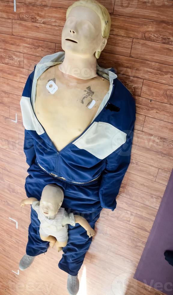 Human dummy lies on the floor during first Aid Training - Cardiopulmonary resuscitation. First aid course on CPR dummy, CPR First Aid Training Concept photo