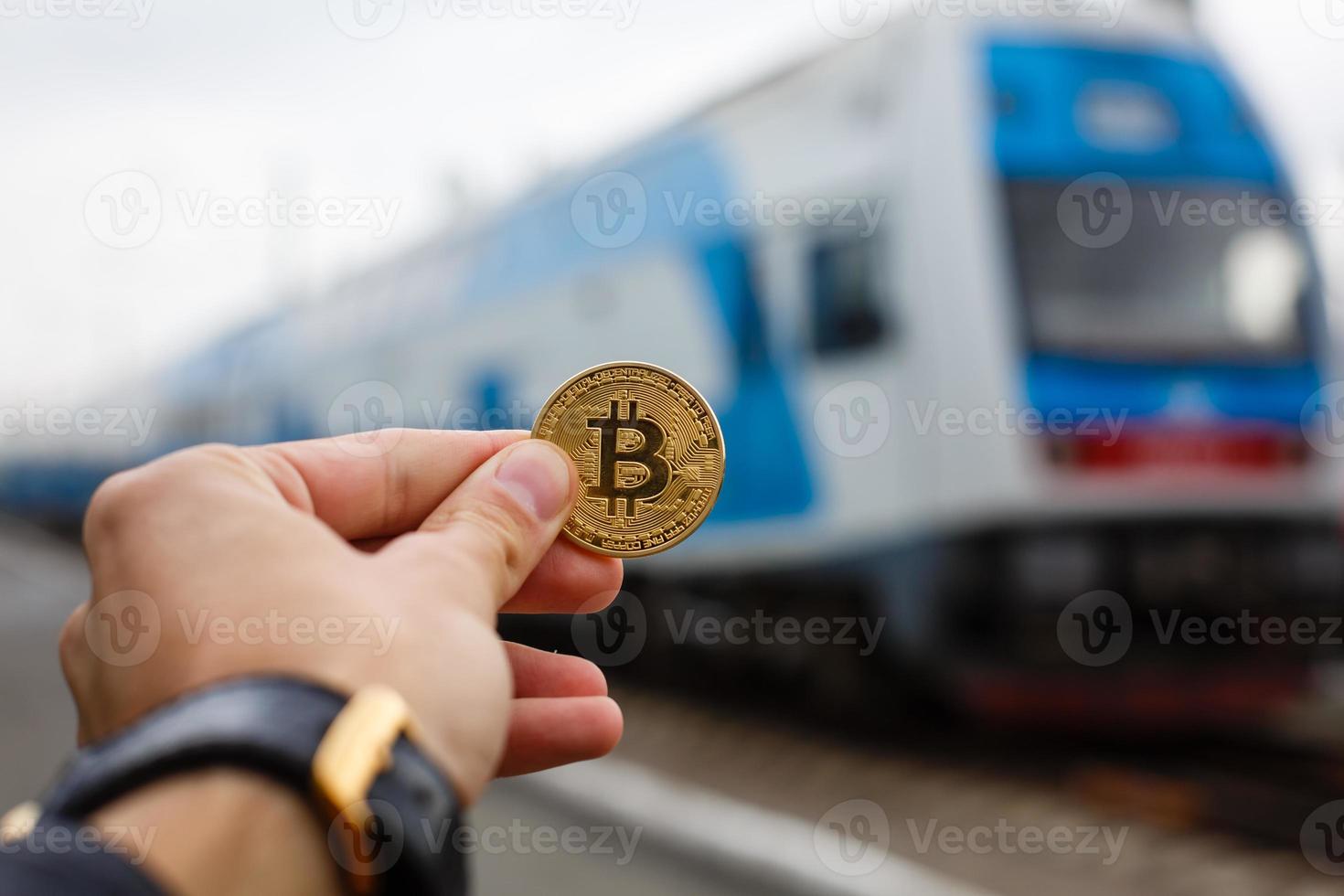 Hand holding golden bitcoin virtual money train photo