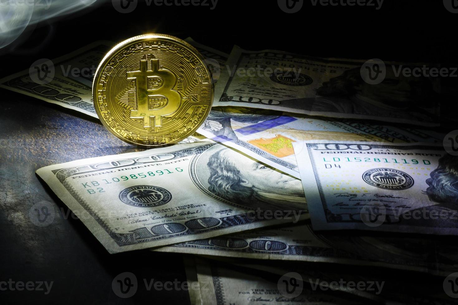 bitcoin dollars on a black background Golden bitcoins with the spotlight photo