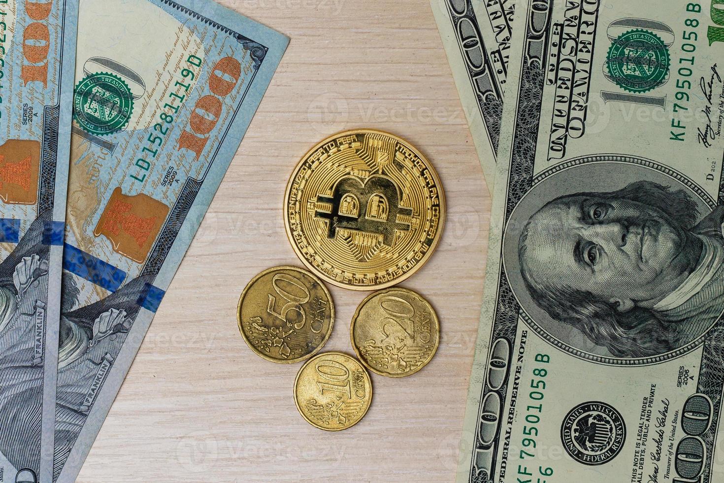 monedas de dólares euros bitcoins sobre un billete de cien dólares foto