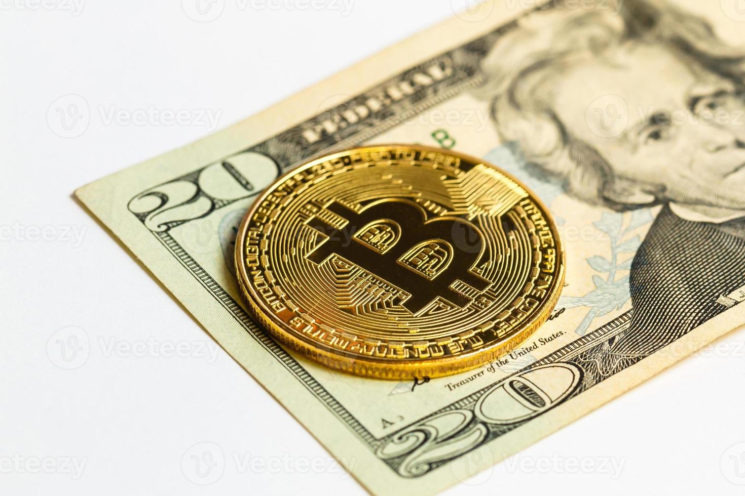 Gold bitcoin on a white background next to us paper money with a face value of dollars photo