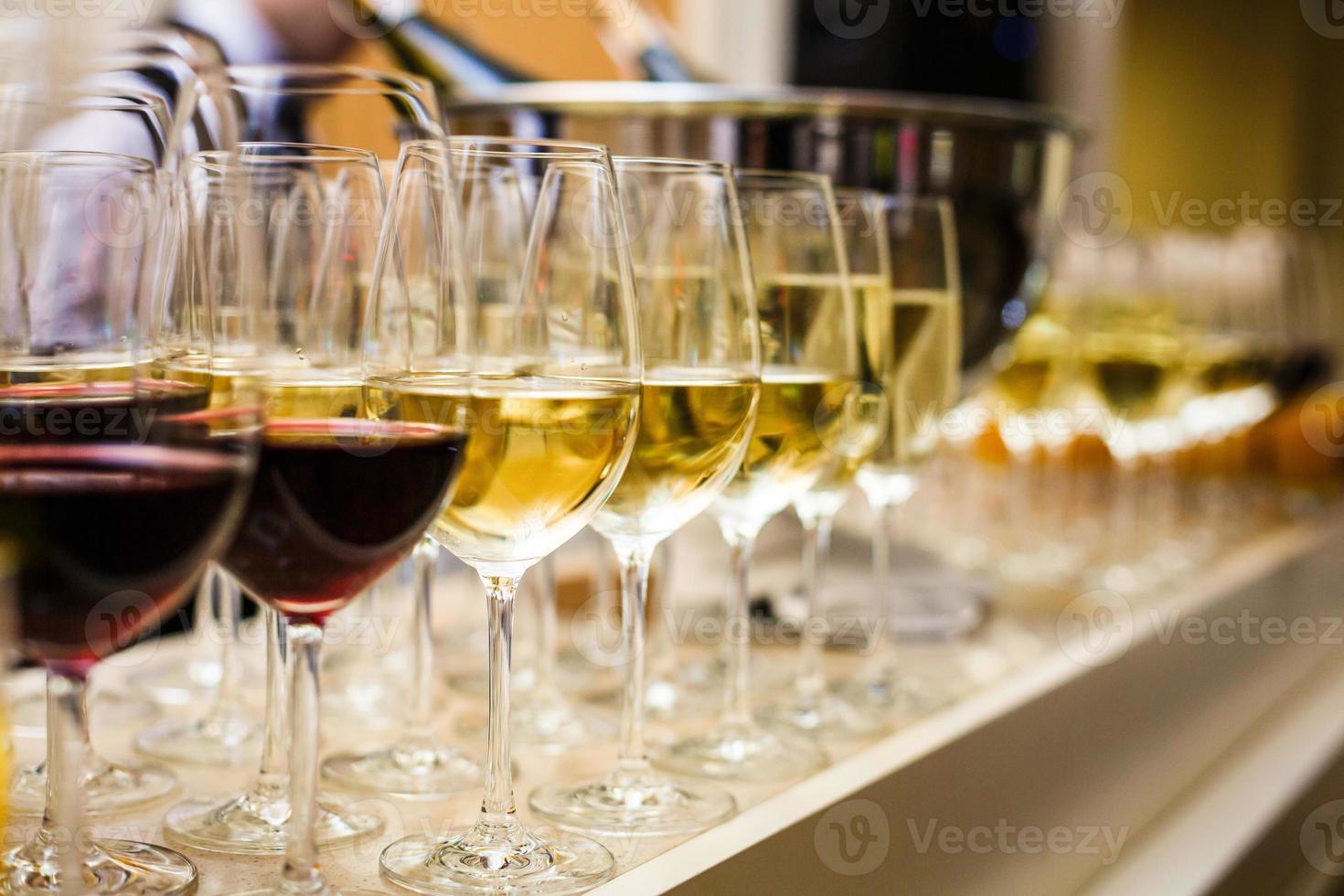 filas de copas de vino con vino tinto y blanco en una mesa de buffet foto