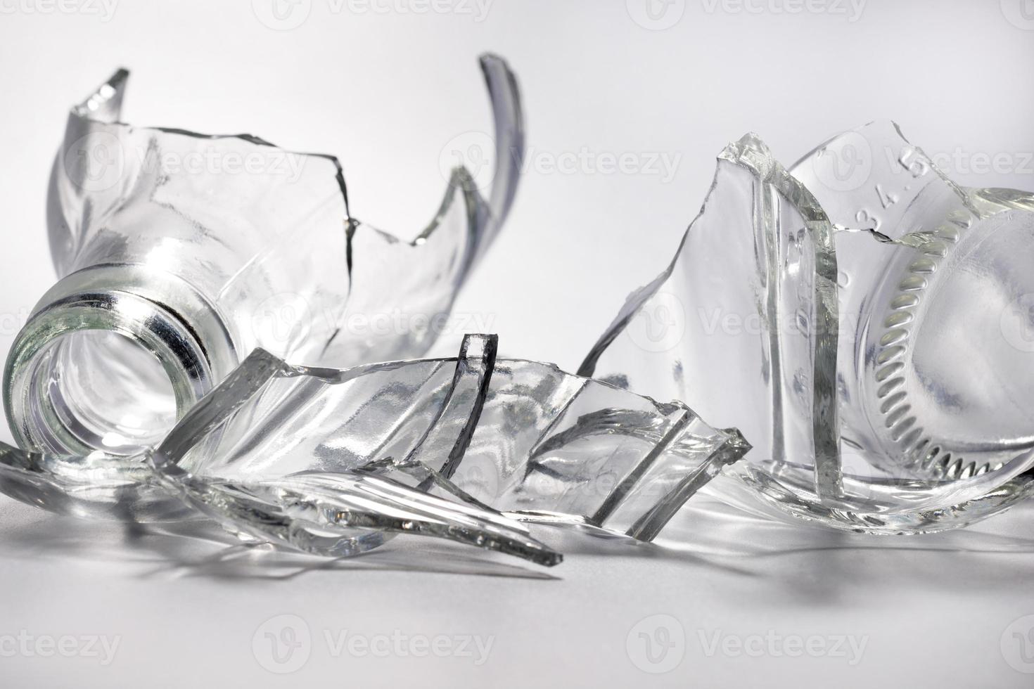 Broken glass bottle. Sharp shards of clear glass. photo