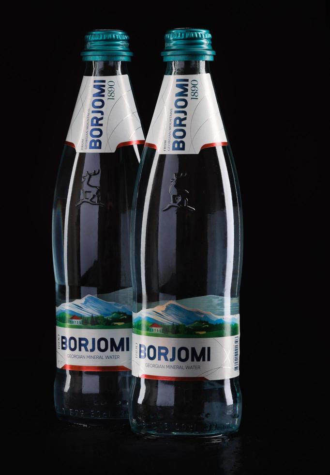 KRASNOYARSK, RUSSIA - OCTOBER 21, 2022 Two bottles of Borjomi natural mineral water on a black background. photo