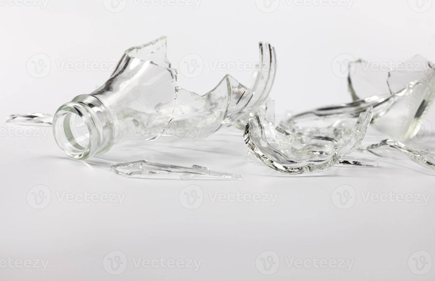 Broken glass bottle. Sharp shards of clear glass. photo
