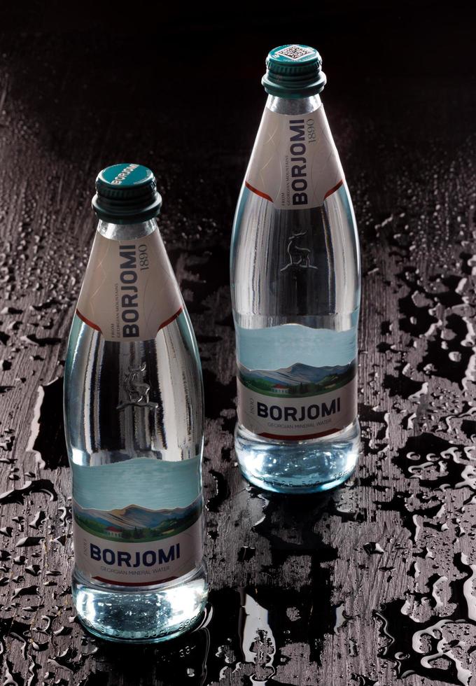 KRASNOYARSK, RUSSIA - OCTOBER 21, 2022 Two bottles of Borjomi natural mineral water on a black background. photo