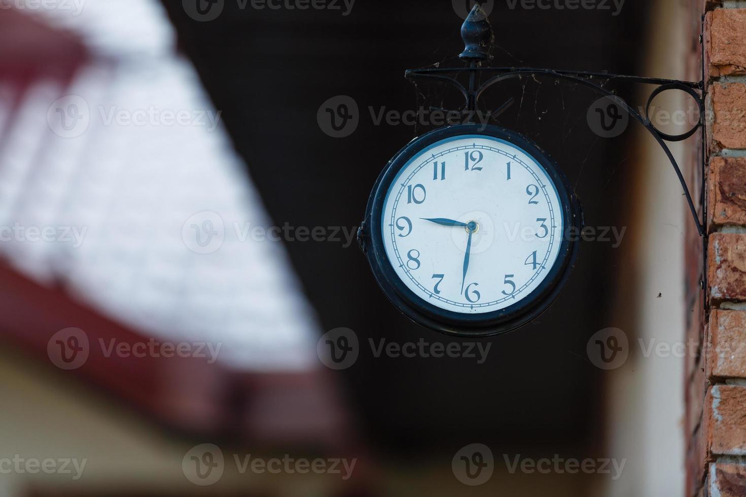 Horas antiguas, reloj de 9.30 horas en una mesa de madera en el jardín verde a las 00:00 foto