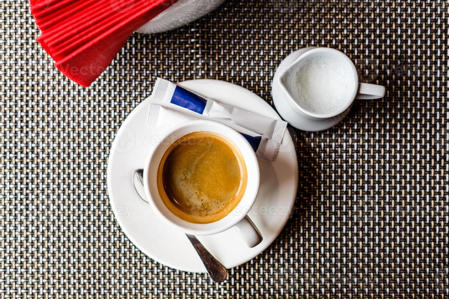 Cup of coffee with foam on table top view metal photo