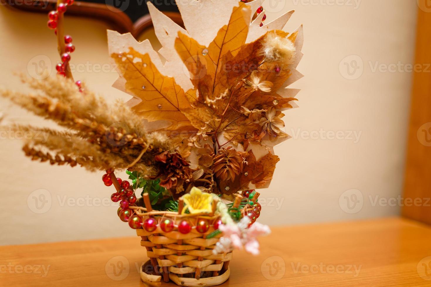 Basket with scattered autumn maple leaves on a white background photo