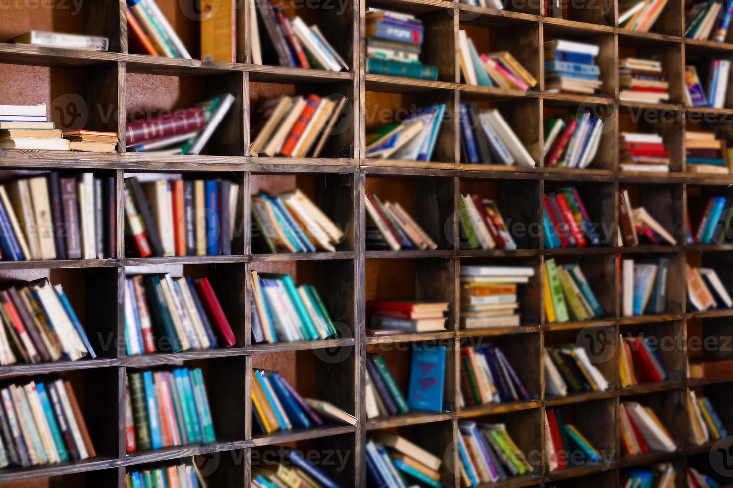 Bookshelf in library with many old books photo