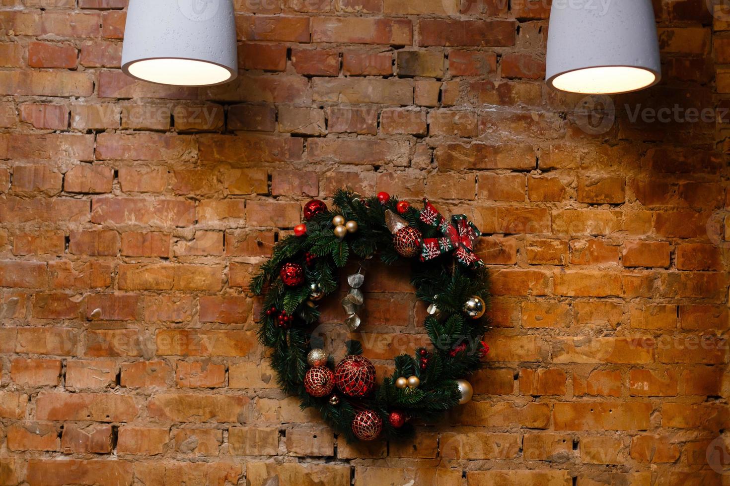 Home made holiday wreath hanging on stone wall. photo