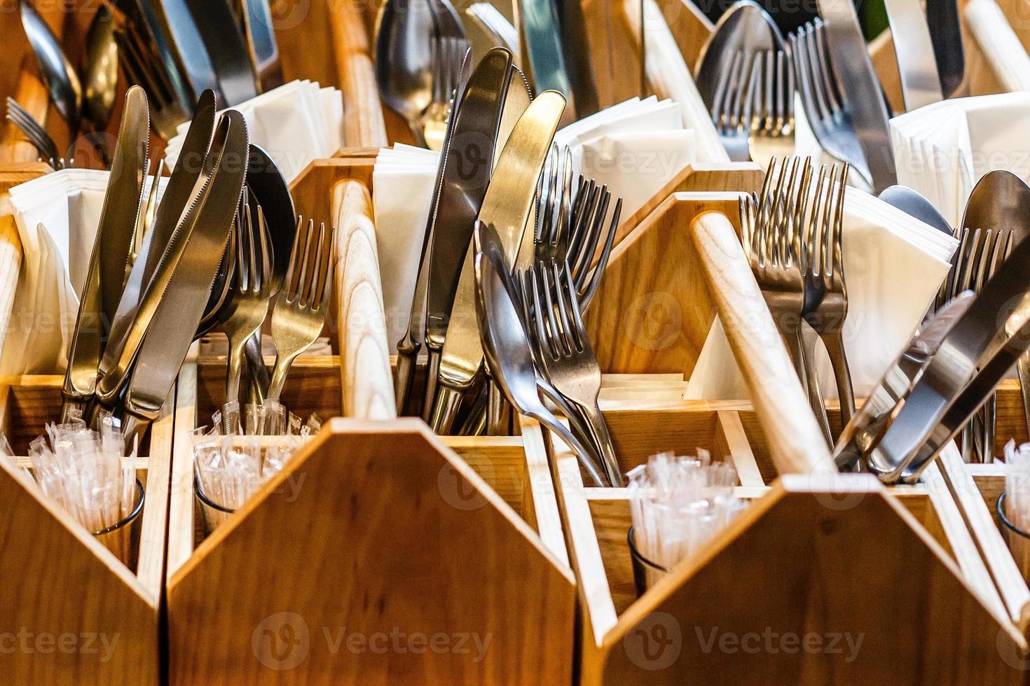 The forks and knives in a wooden stand photo