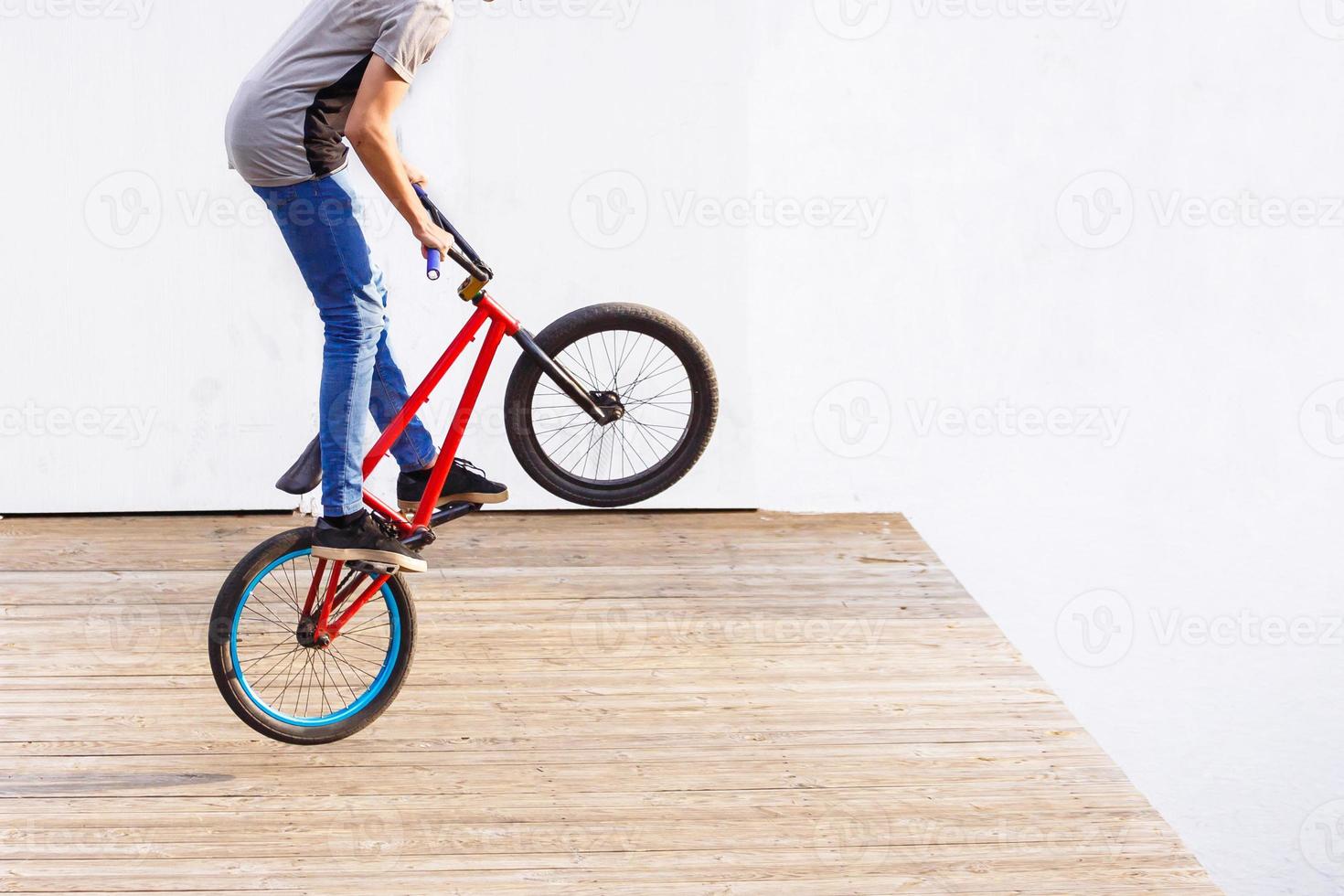 Persona montando en bicicleta en salto aislado contra el fondo blanco. foto