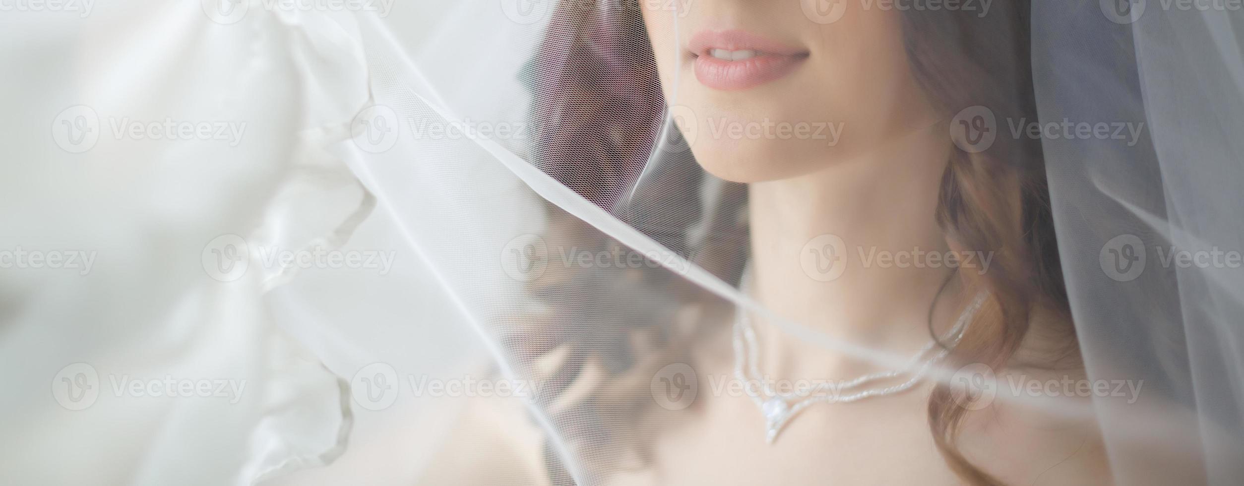Close up portrait of a pretty shy bride with a veil photo