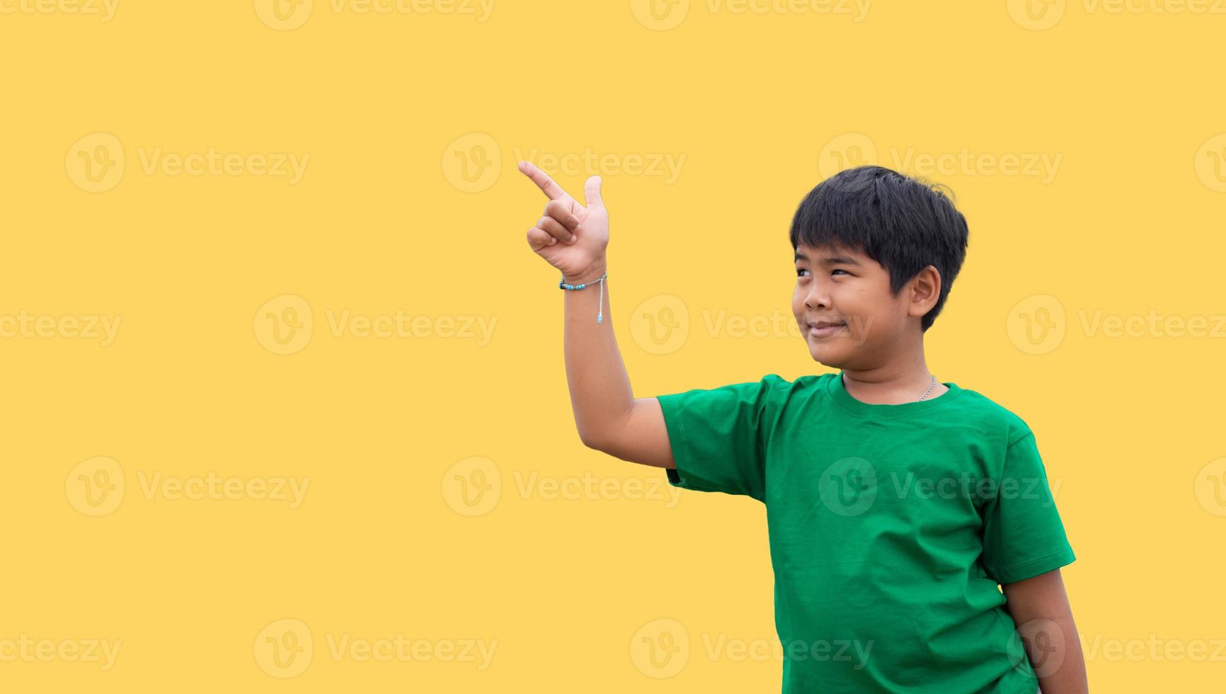 The boy smiled and pointed his hand to his side. on a yellow background photo