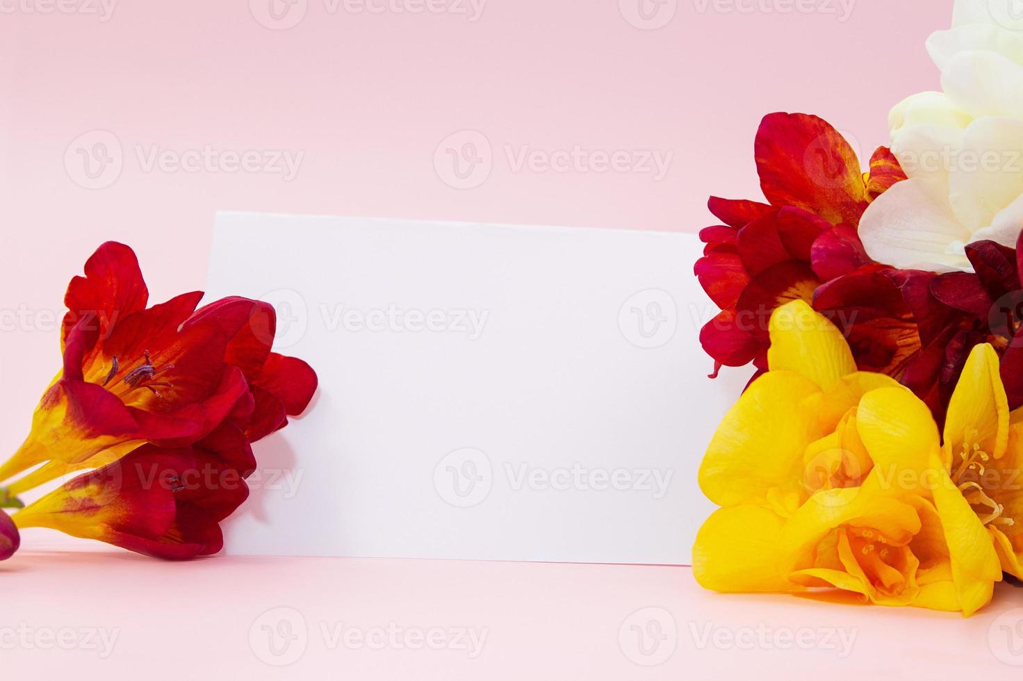Bouquet of yellow and red freesias with paper for text. Holidays, International women's, Mother's day, birthday, March 8. Copy space photo