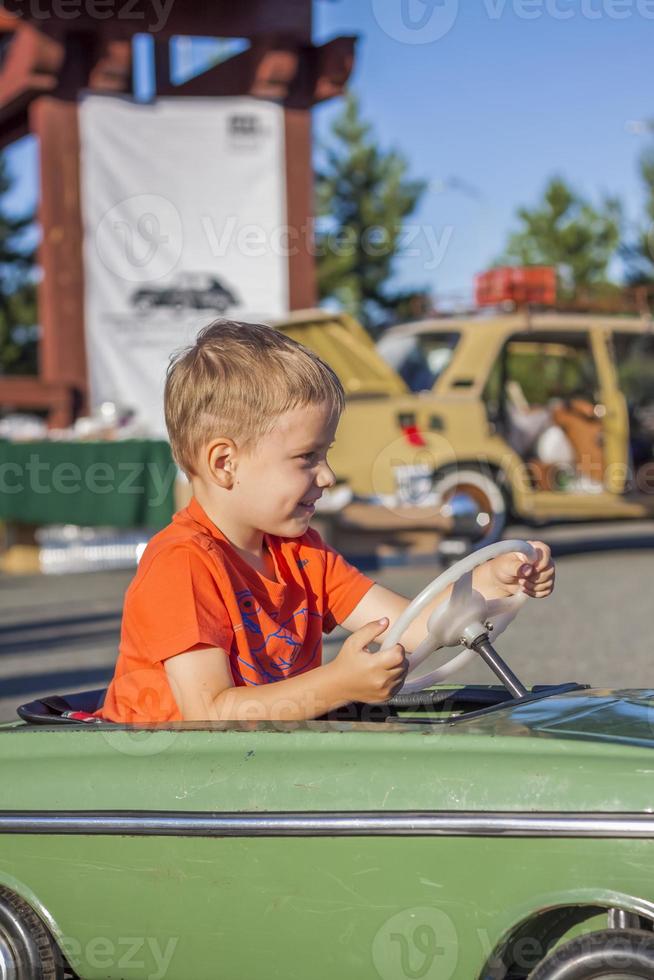 A boy driving a children's car. Joyful emotions. Children, portrait. photo