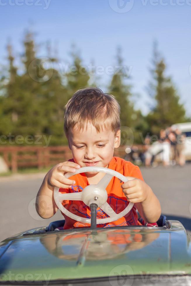 A boy driving a children's car. Joyful emotions. Children, portrait. photo