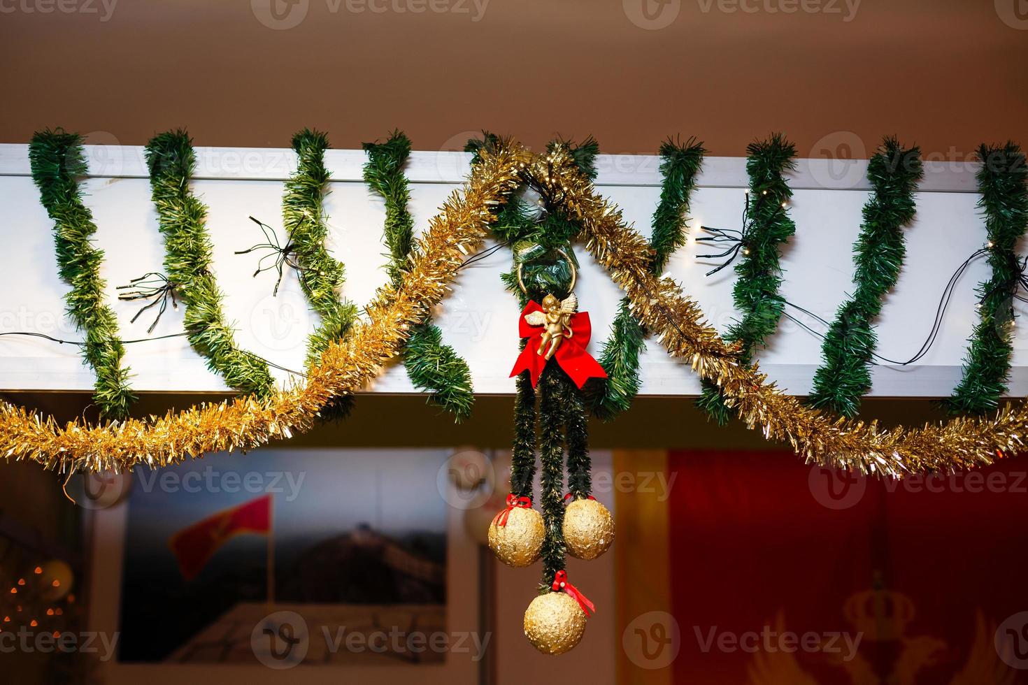 muñeco de trapo de ángel de navidad colgando. en medio de un candelero festivo con velas. celebración de año nuevo y navidad en casa foto