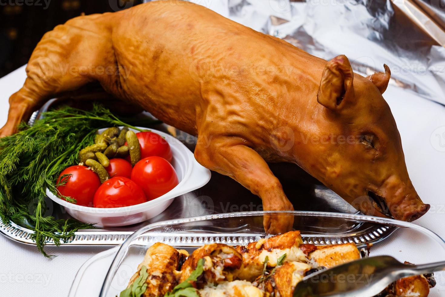 roasted pig on a bed of lettuce. buffet table photo