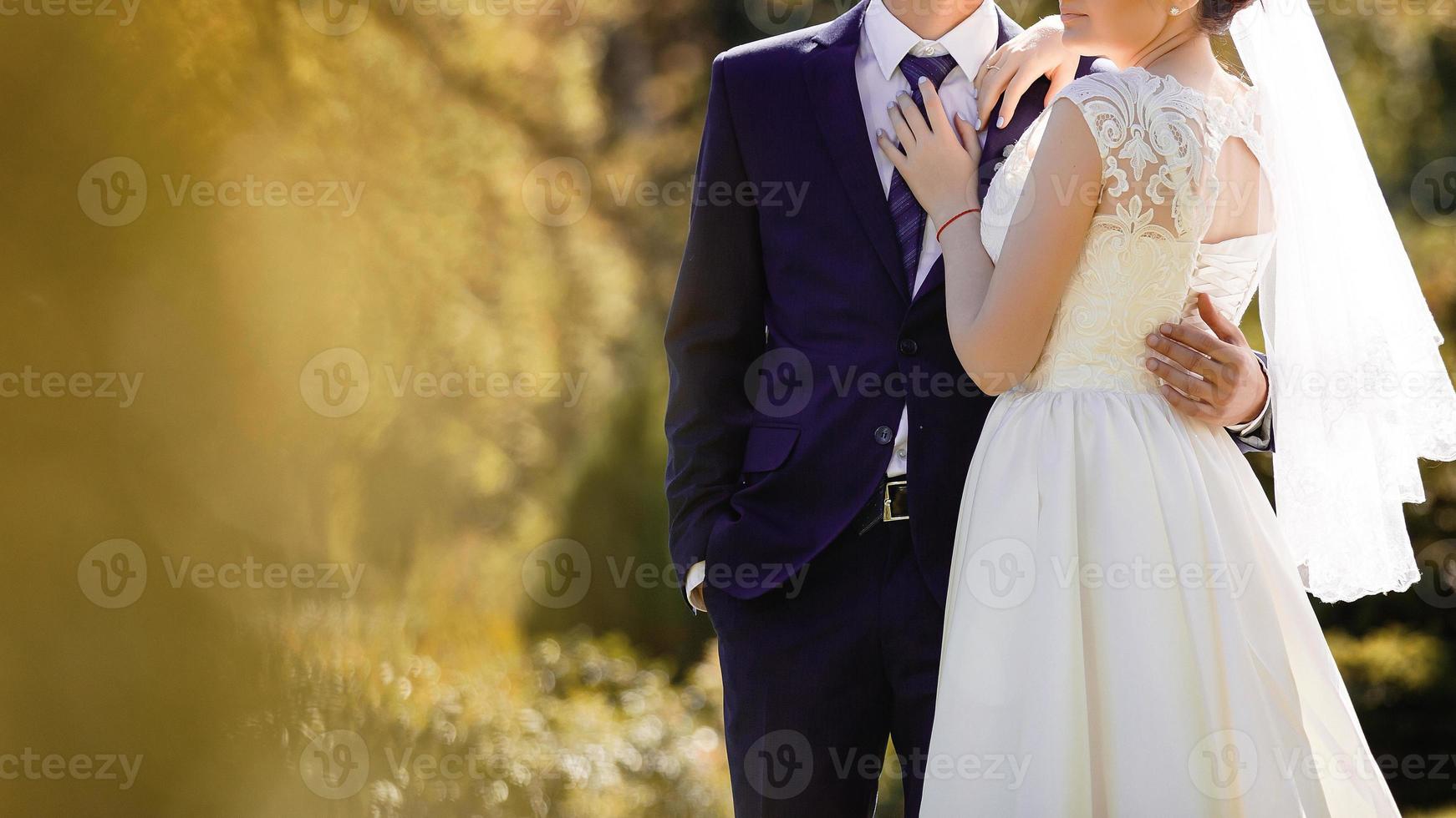 Sunshine portrait of happy bride and groom outdoor in nature location at sunset warm summertime photo
