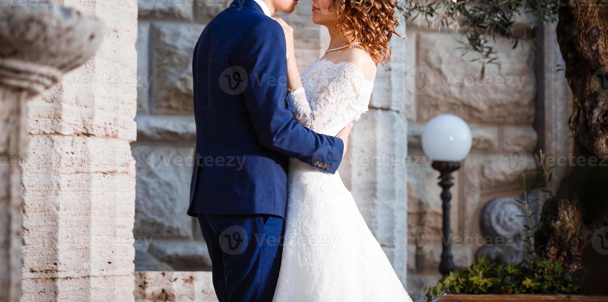 Portrait of happy bride and groom near columns photo