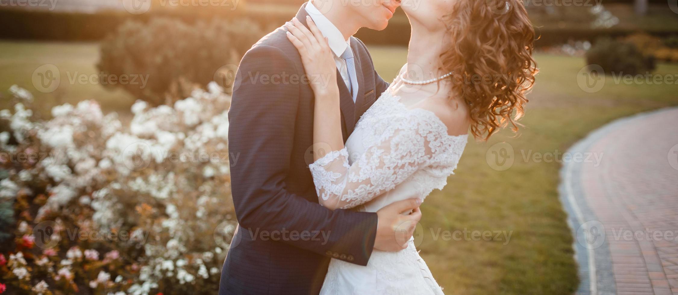 Sunshine portrait of happy bride and groom outdoor in nature location at sunset warm summertime photo