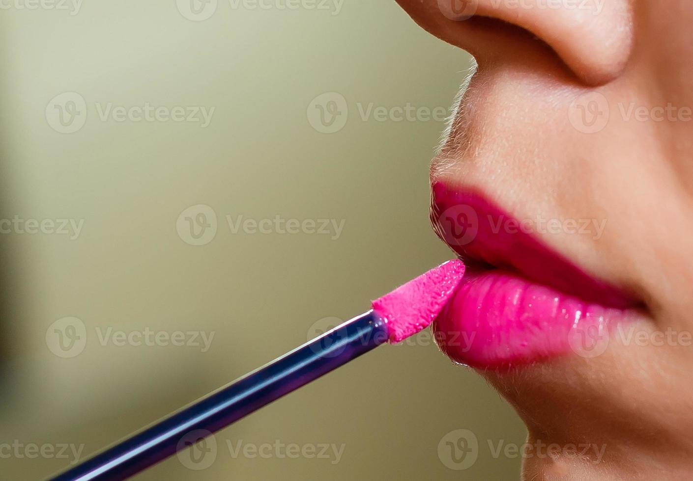 Woman painted pink lips. Beauty lips make-up. Perfect skin, full lips. Retro make up. Professional make-up artist applying sexy lips makeup. Fashion makeup photo