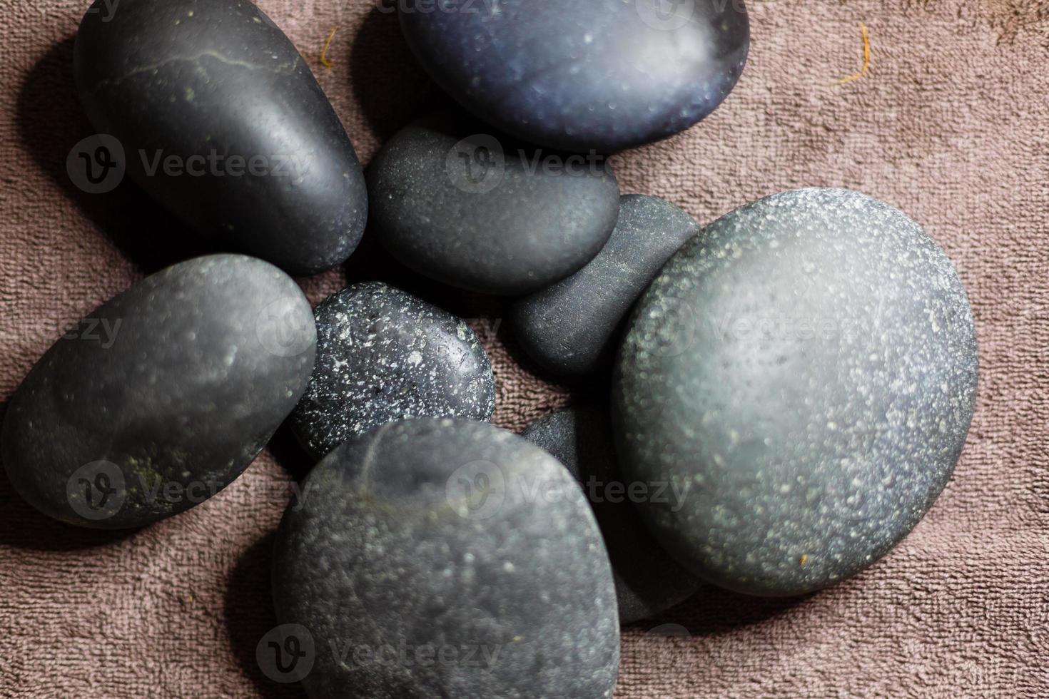 piedras de spa calientes con bambú sobre fondo gris, primer plano foto