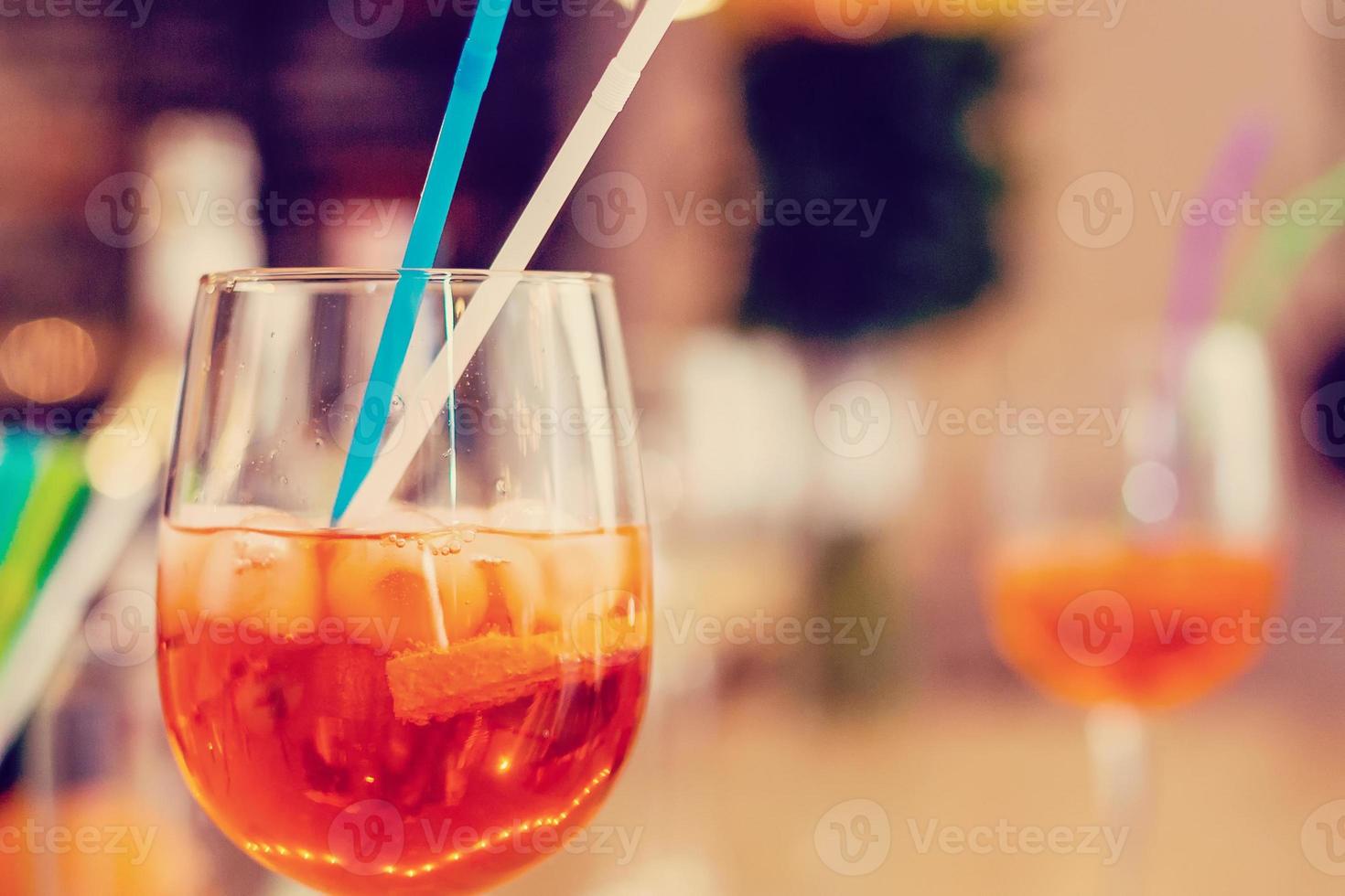 Glass of orange cocktail decorated at bar counter background. photo