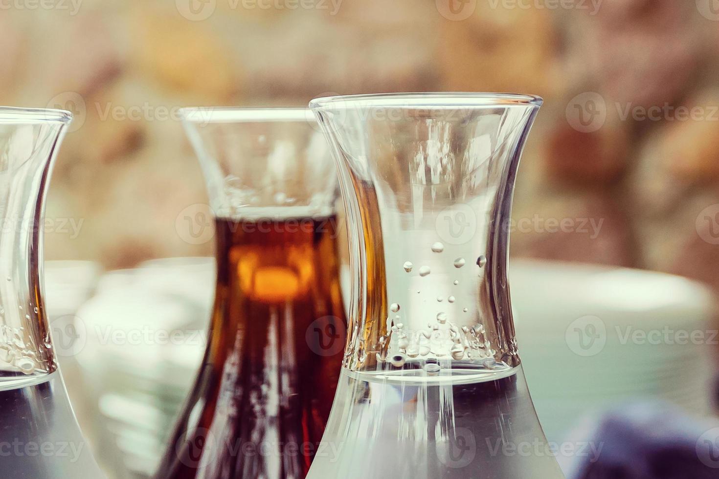 Drink waterin to glass over sunlight and natural green background photo