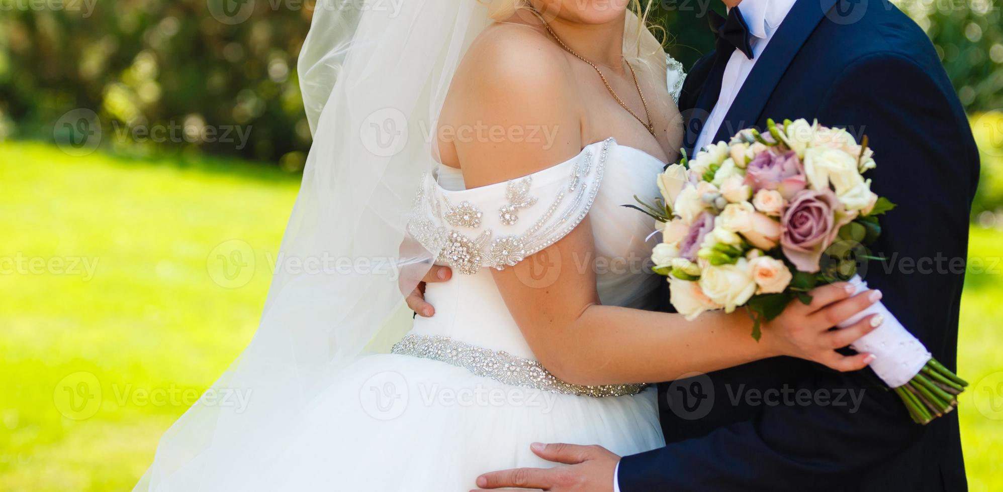 pareja de recién casados bailando valse al aire libre, espacio libre. abrazos de novia y novio, fondo de hierba verde borroso. primer concepto de baile de boda foto