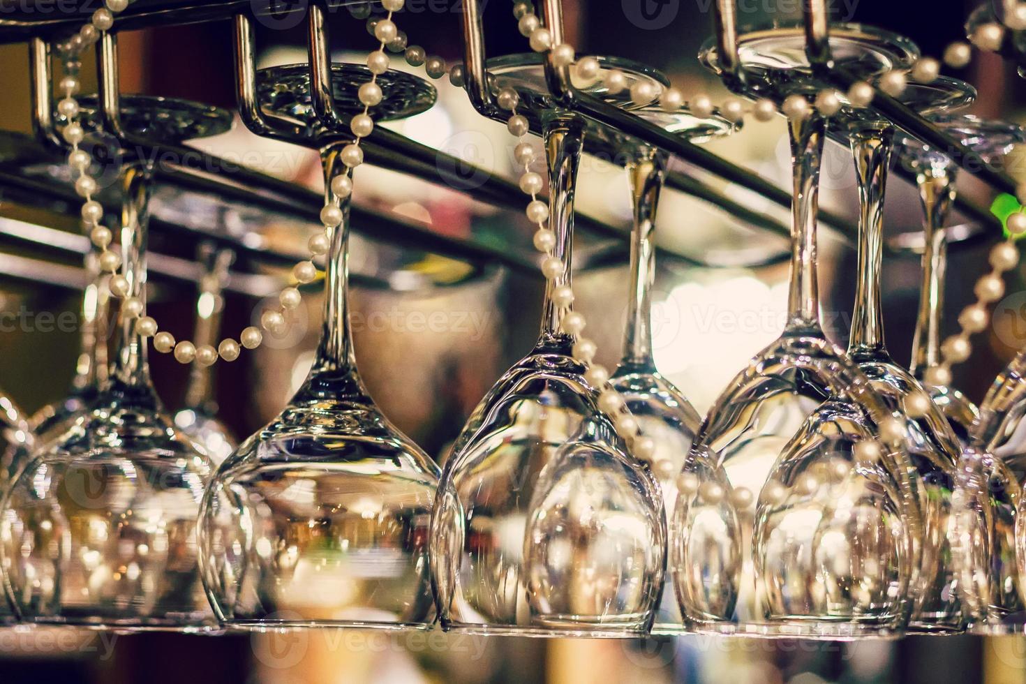 Empty glasses for wine above a bar rack photo