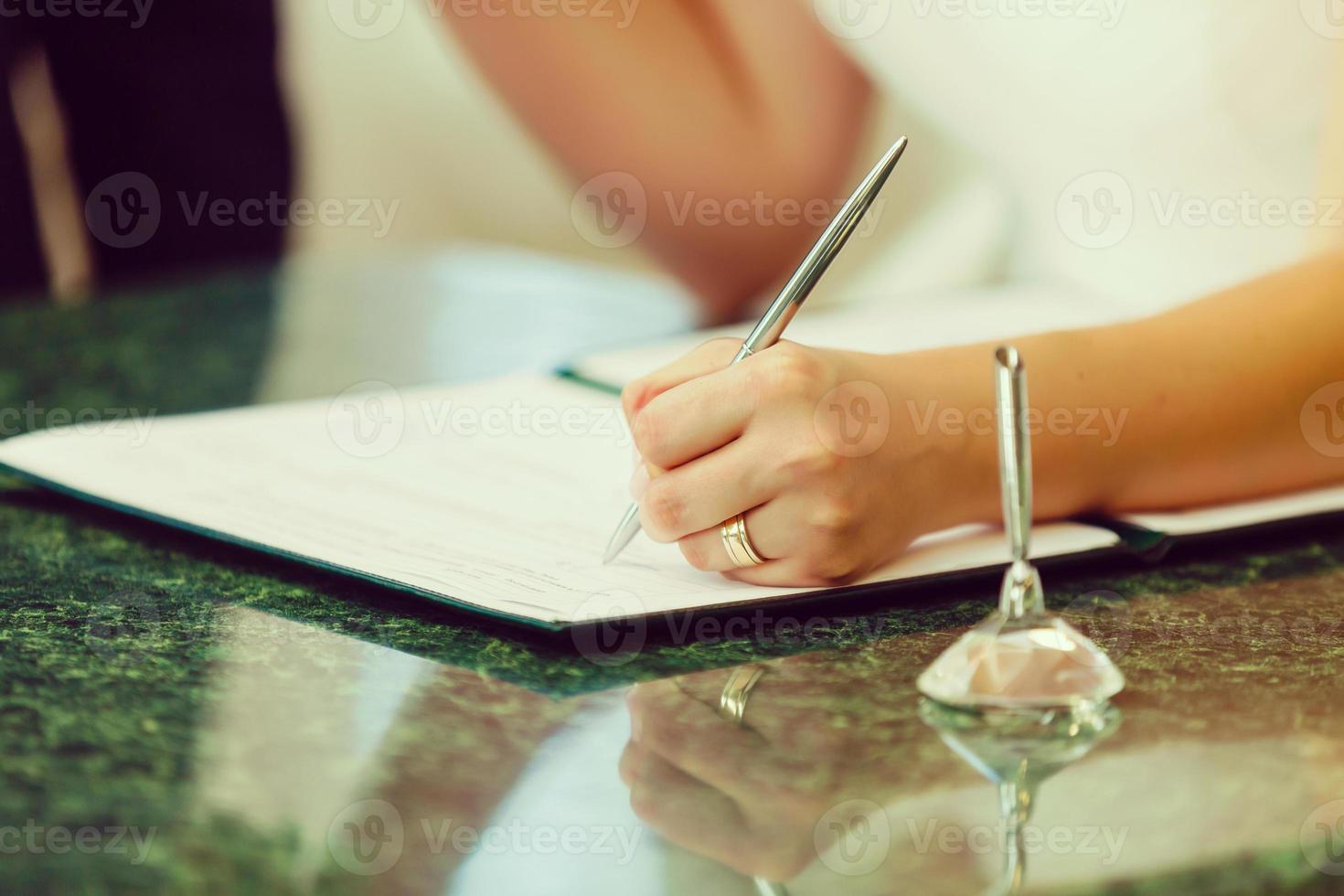 Businesswoman's hand with pen completing personal information on a form photo