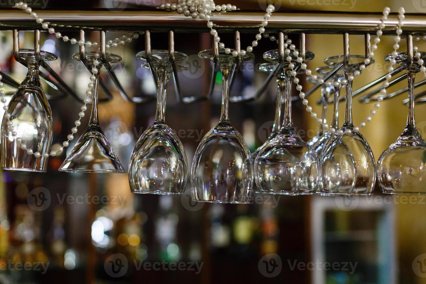 Empty glasses for wine above a bar rack photo